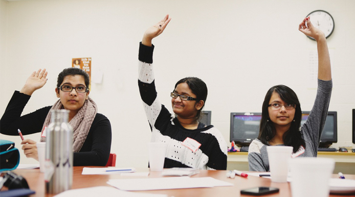 students with hands raised