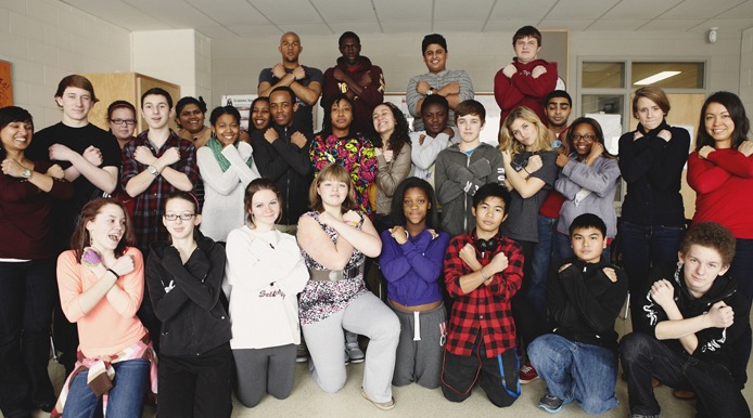 a class with everyone making a cross with their arms